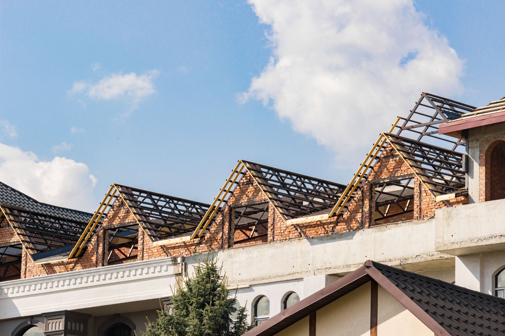 Partially constructed roof with exposed trusses on a large commercial building.