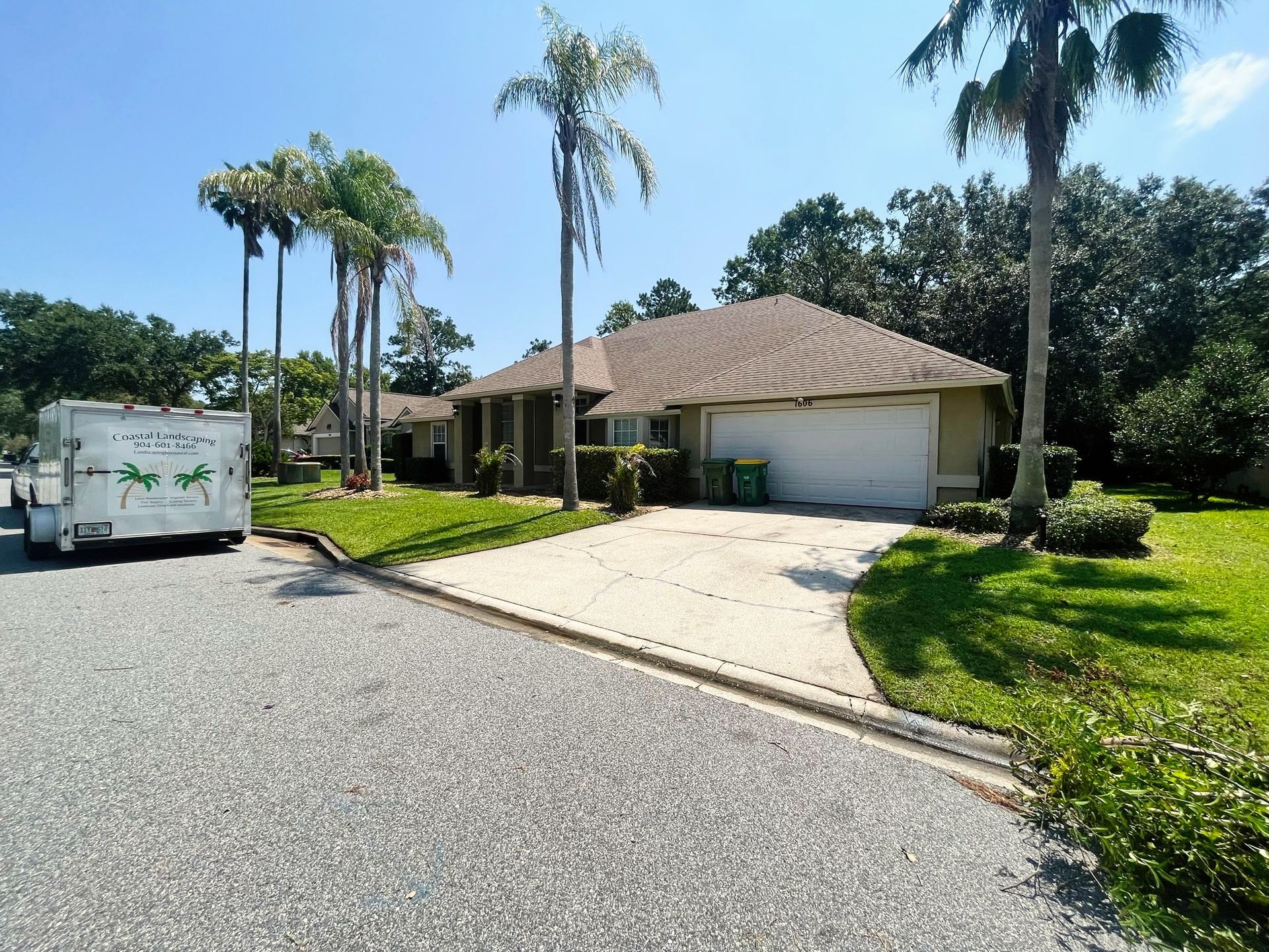 A house with a white trailer parked in front of it