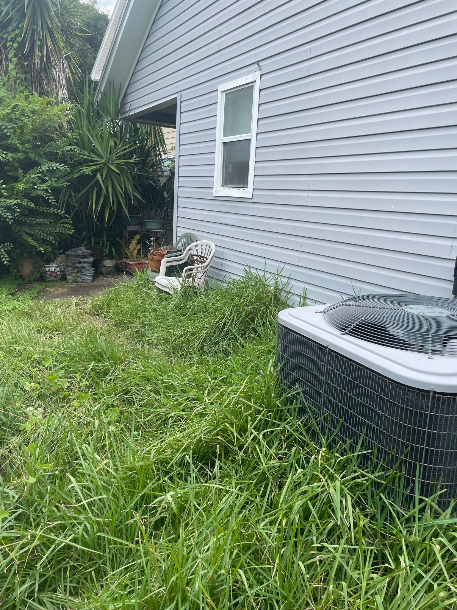 A house with a air conditioner in the backyard.