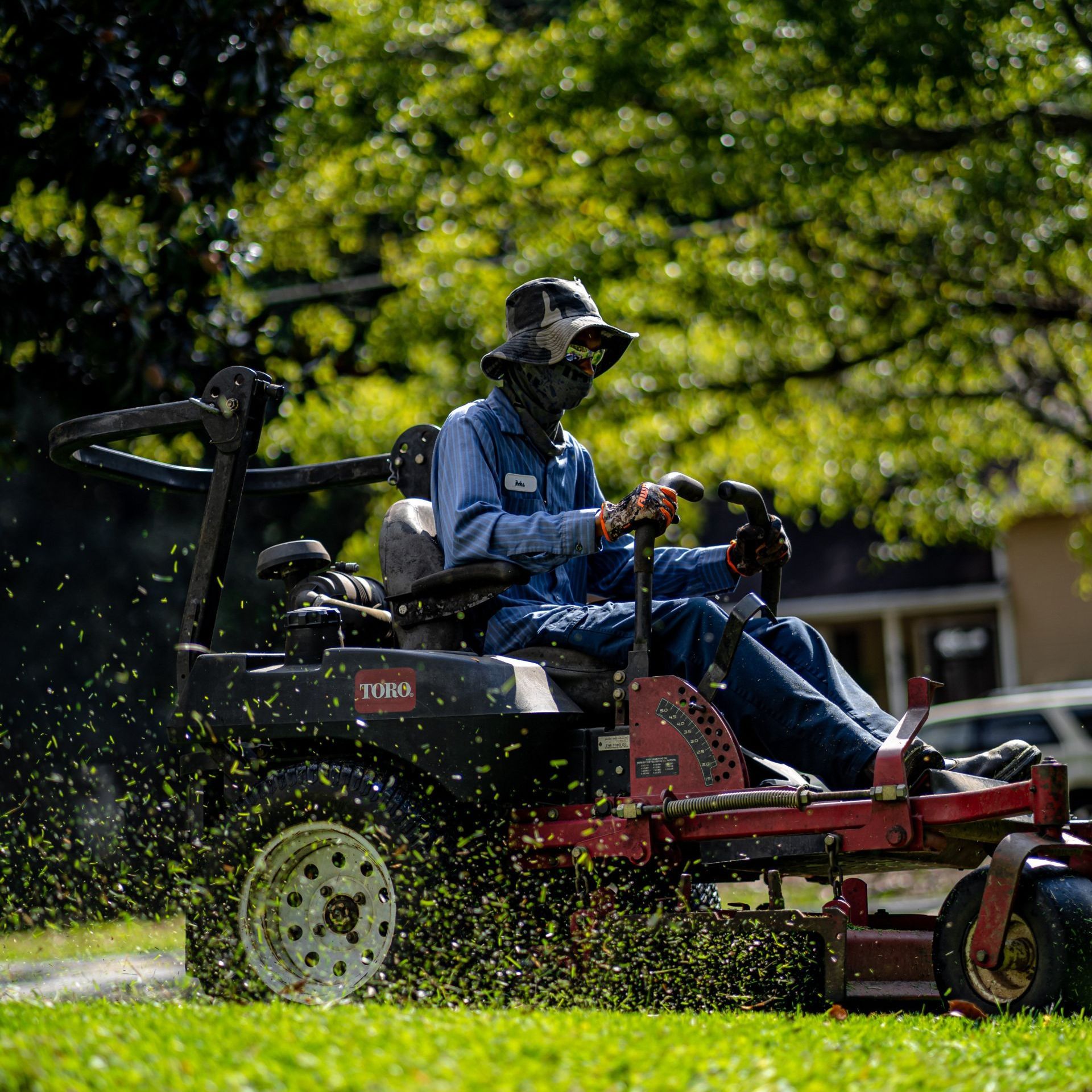 A man is riding a lawn mower on a lush green field.