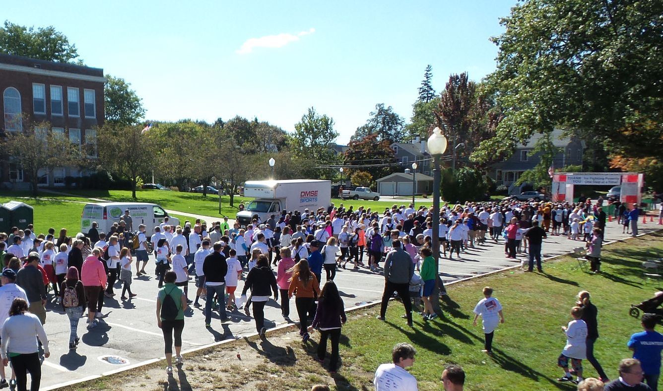 A large group of people are walking down a street