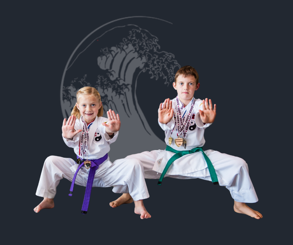 A boy and a girl are practicing karate in front of a wave.