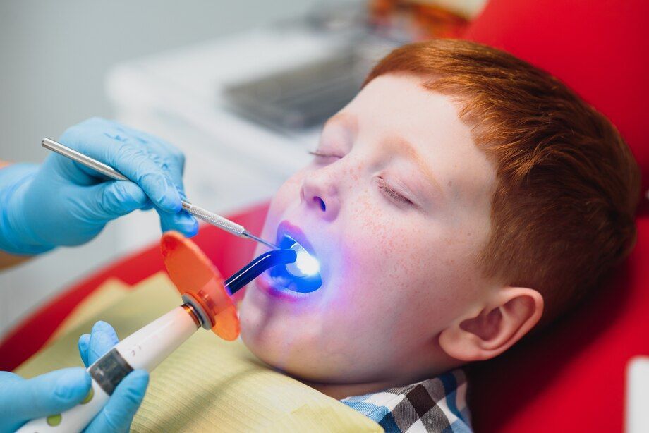 A young boy is getting his teeth examined by a dentist.