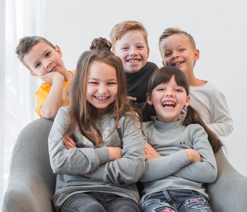 A group of children are posing for a picture while sitting in a chair.