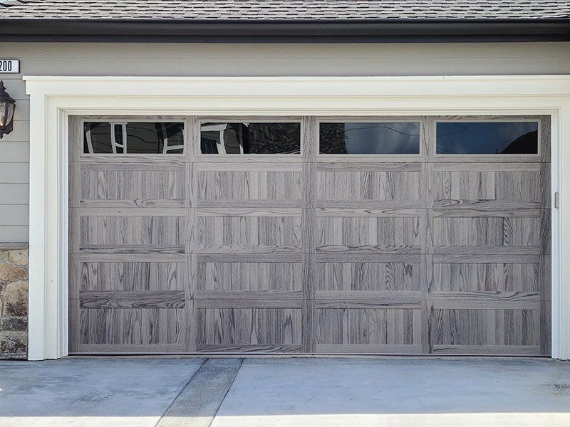 A large wooden garage door is open to a house.