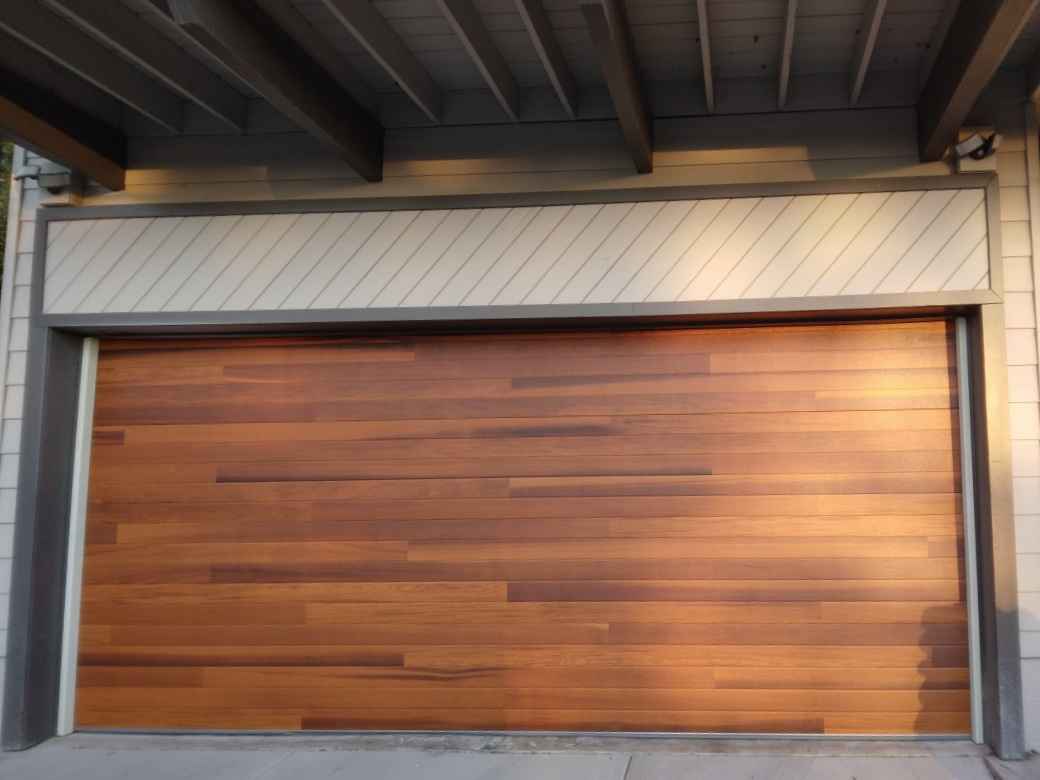 A wooden garage door with a white trim