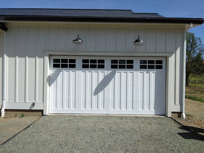 A white garage door with a solar panel on the roof