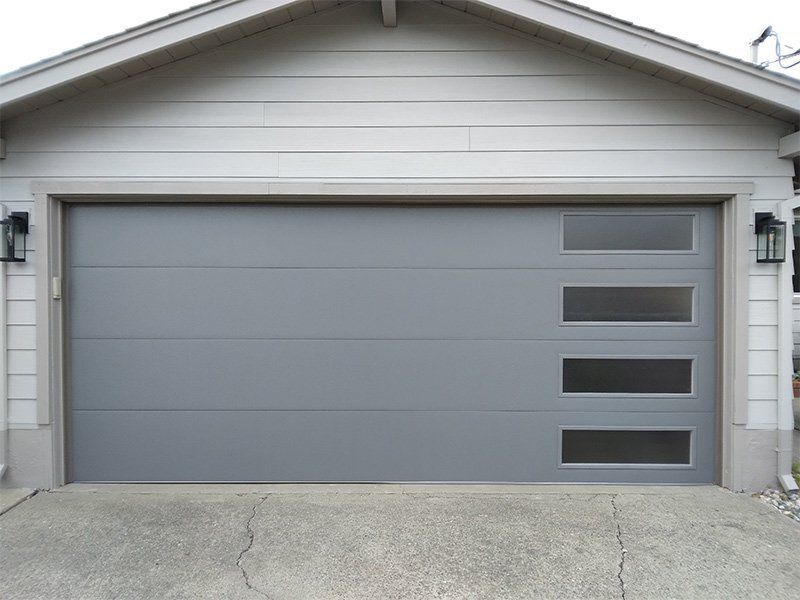 A white house with a gray garage door