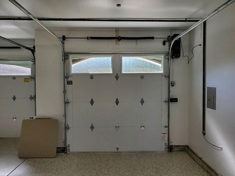 An empty garage with a white garage door