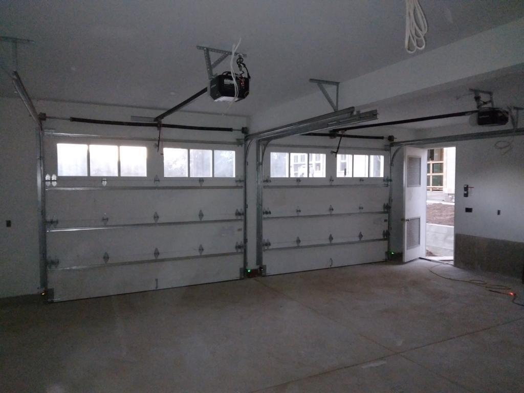 An empty garage with a garage door open and a ceiling fan