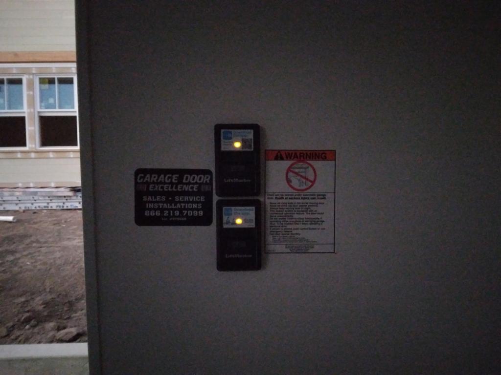 A garage door with a warning sign on it