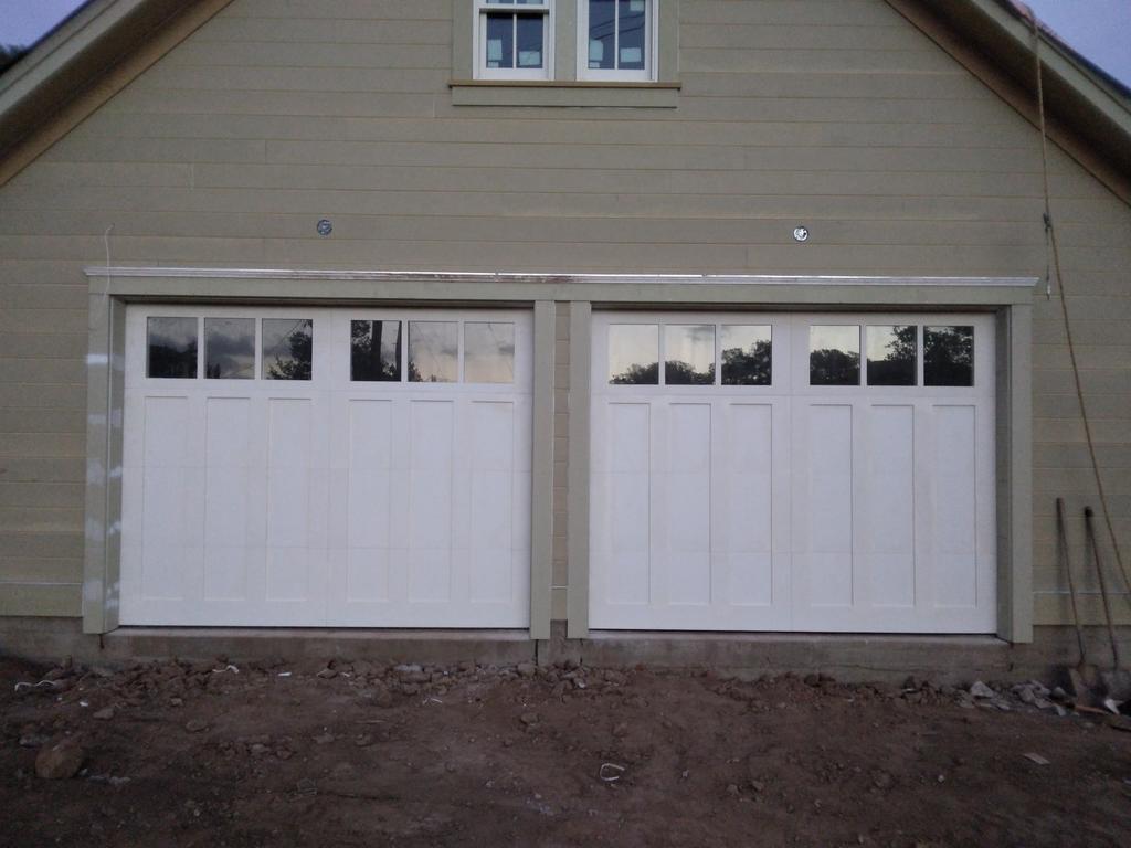 A garage with two white garage doors and a window