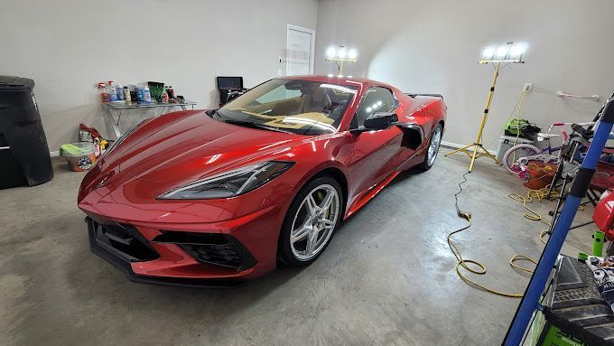 A red sports car is parked in a garage.