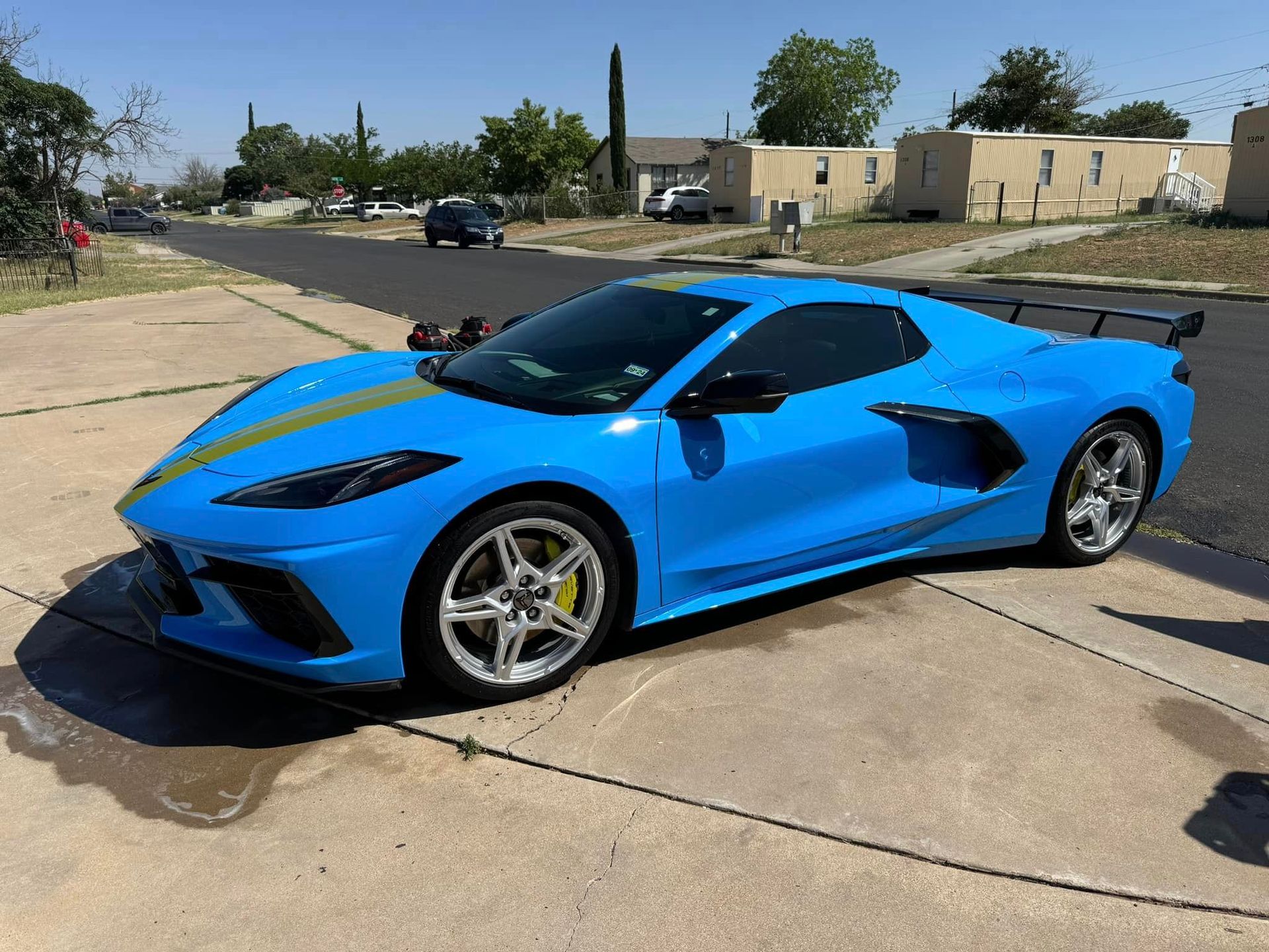 A blue sports car is parked on the side of the road.