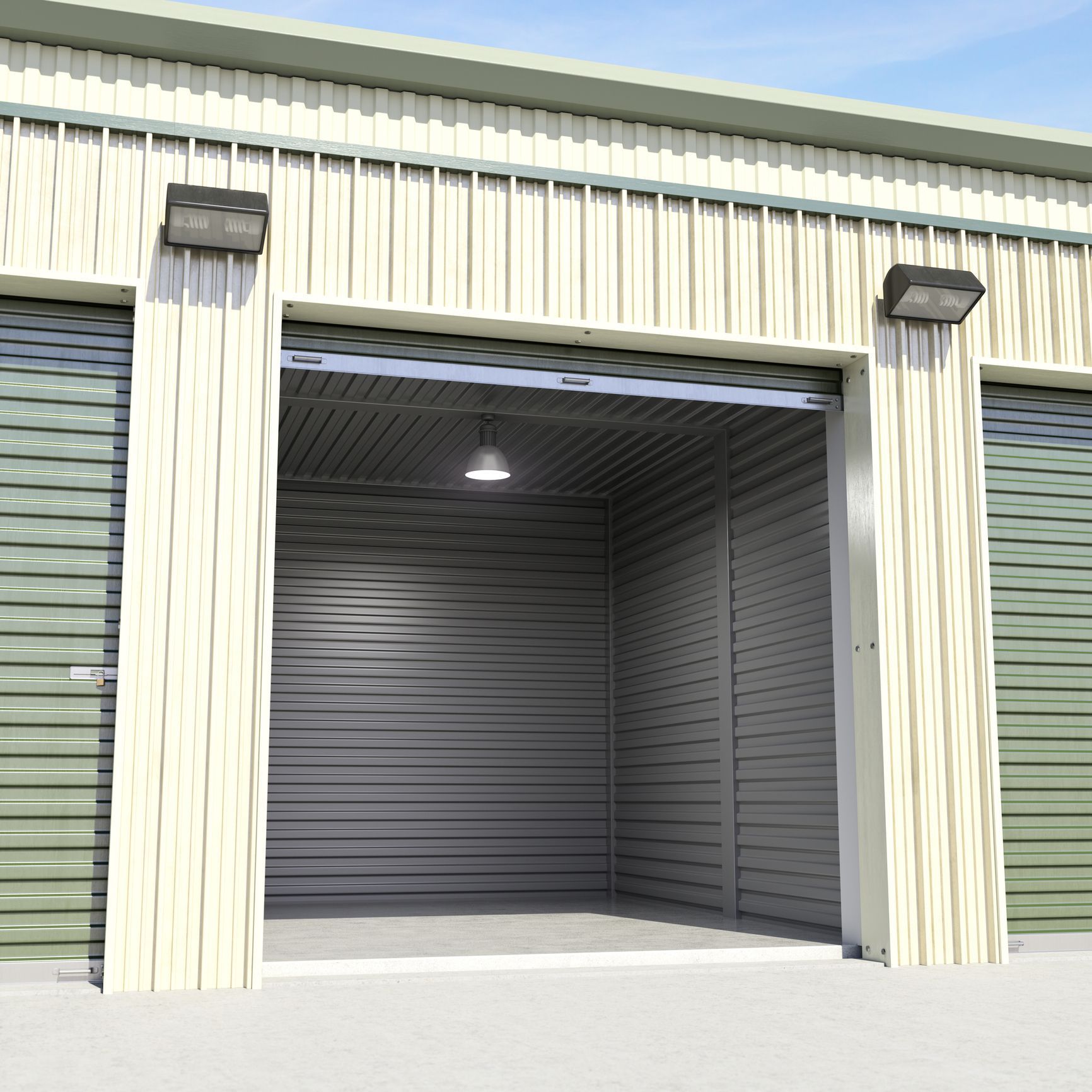 Open industrial storage bay with gray corrugated metal walls and roll-up doors on both sides