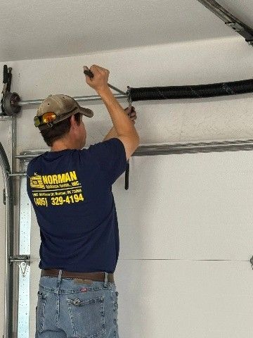 A man is working on a garage door.