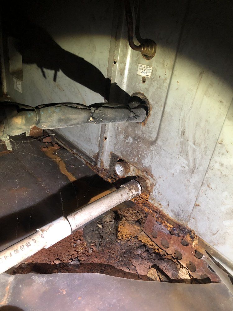 A close up of a rusty piece of metal with a pipe sticking out of it.