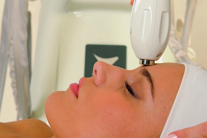 Una donna sta ricevendo un trattamento viso in un salone di bellezza.