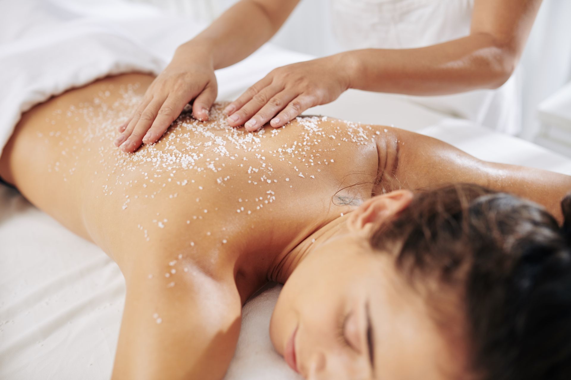 Una donna sta ricevendo uno scrub per il corpo in una spa.