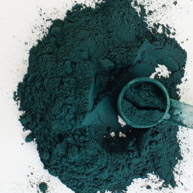 Spicula verde del trattamento biomicroneedling ice da Beauty Lounge Un mucchio di polvere verde con dentro un misurino
