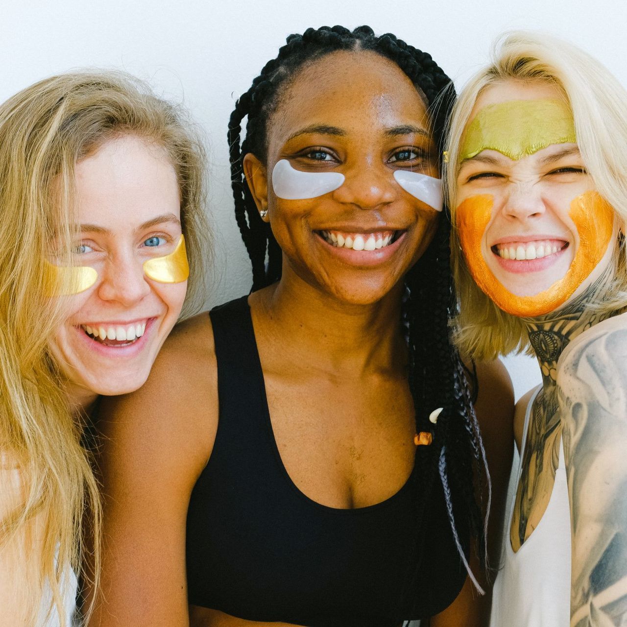 tre donne sorridenti durante un trattamento viso Tre donne che indossano maschere facciali sorridono alla telecamera