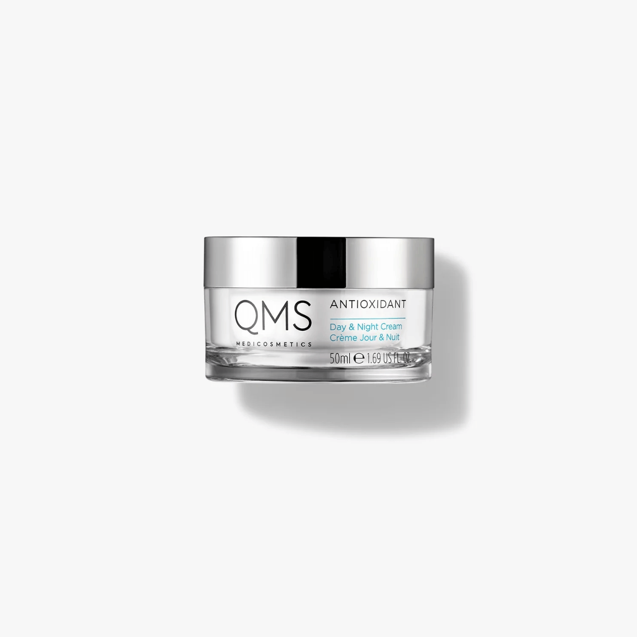 Un vasetto di crema qms su sfondo bianco.