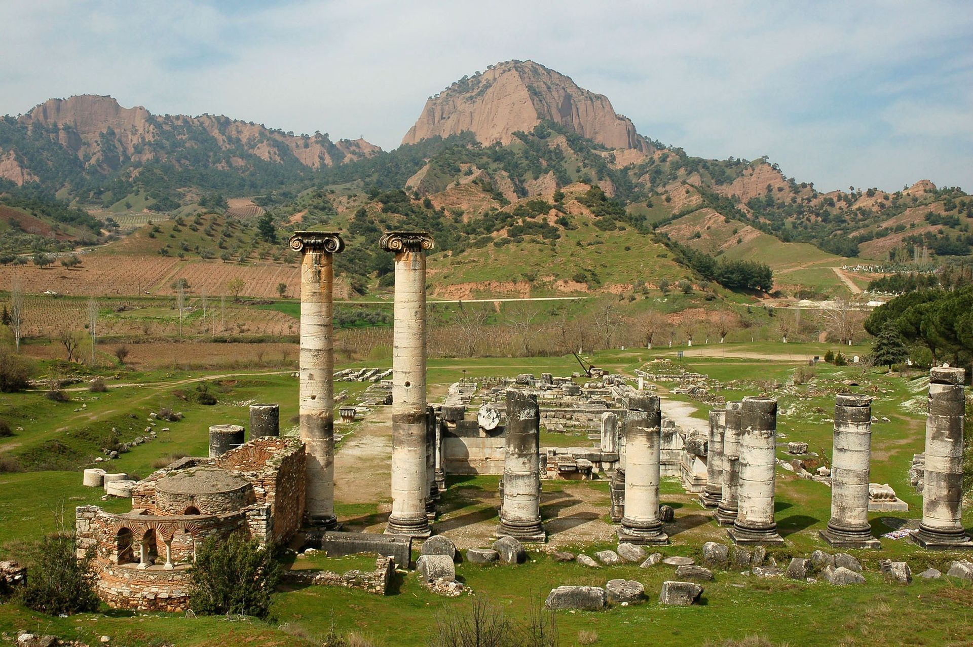 Ruins of ancient Sardis, Turkey, with tall columns against a mountain backdrop.