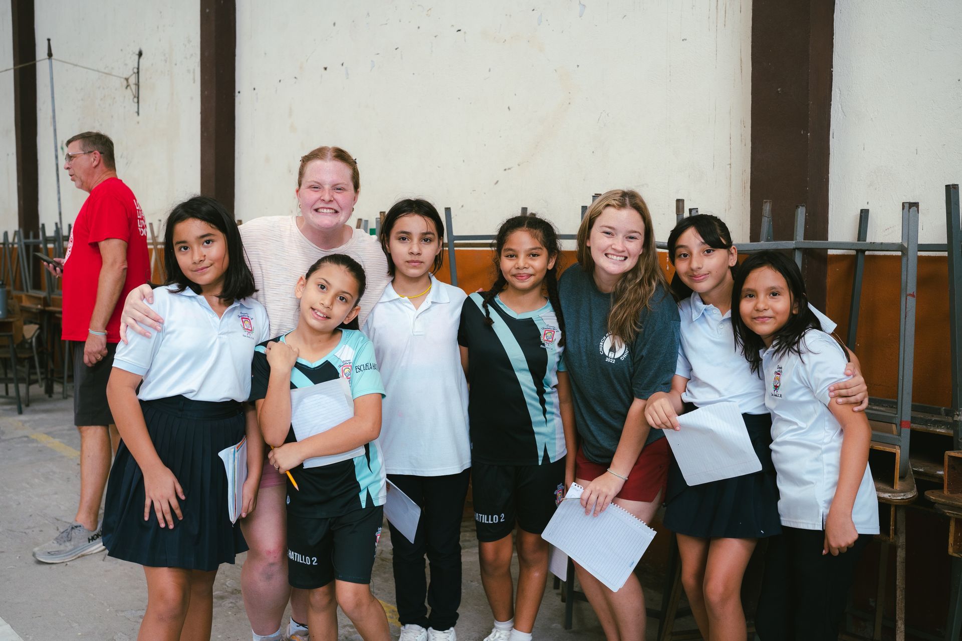 A group of young girls are posing for a picture with their teacher.