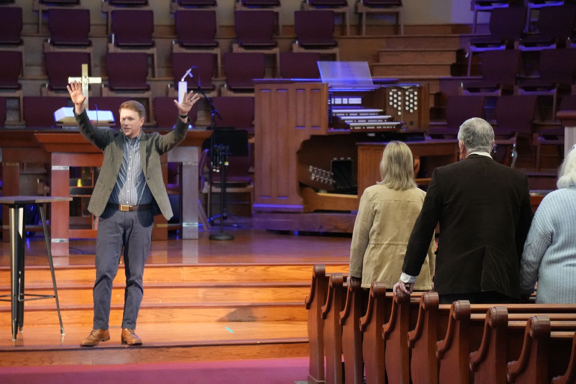A man is playing a guitar in front of a crowd of people in a church.