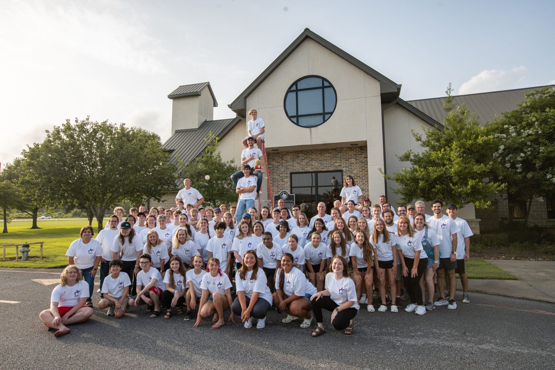 A large group of people are posing for a picture in front of a church.