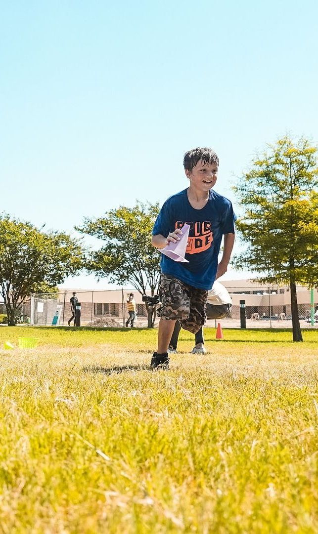 A young boy is running through a grassy field.