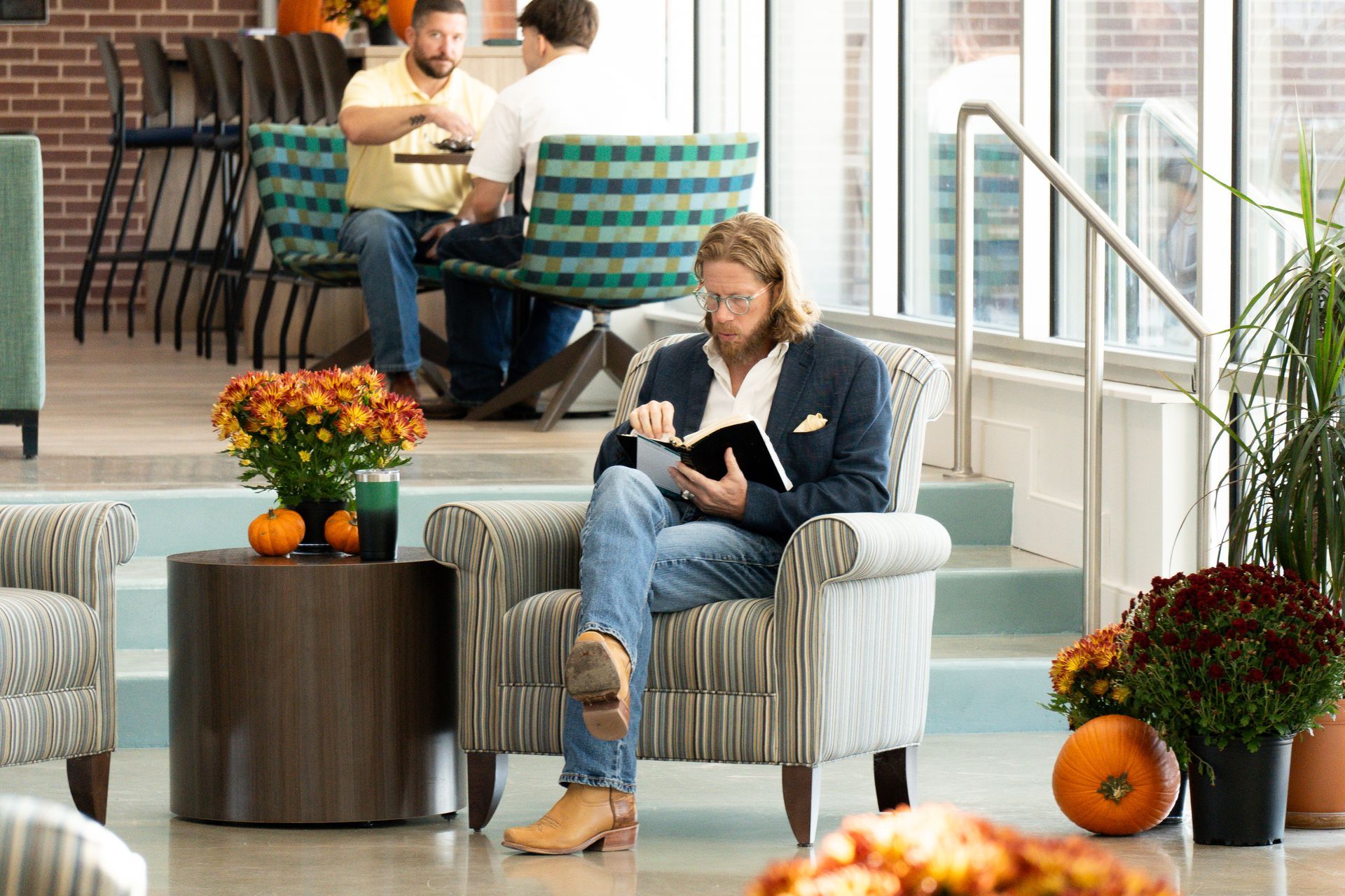A man is sitting in a chair reading a book.
