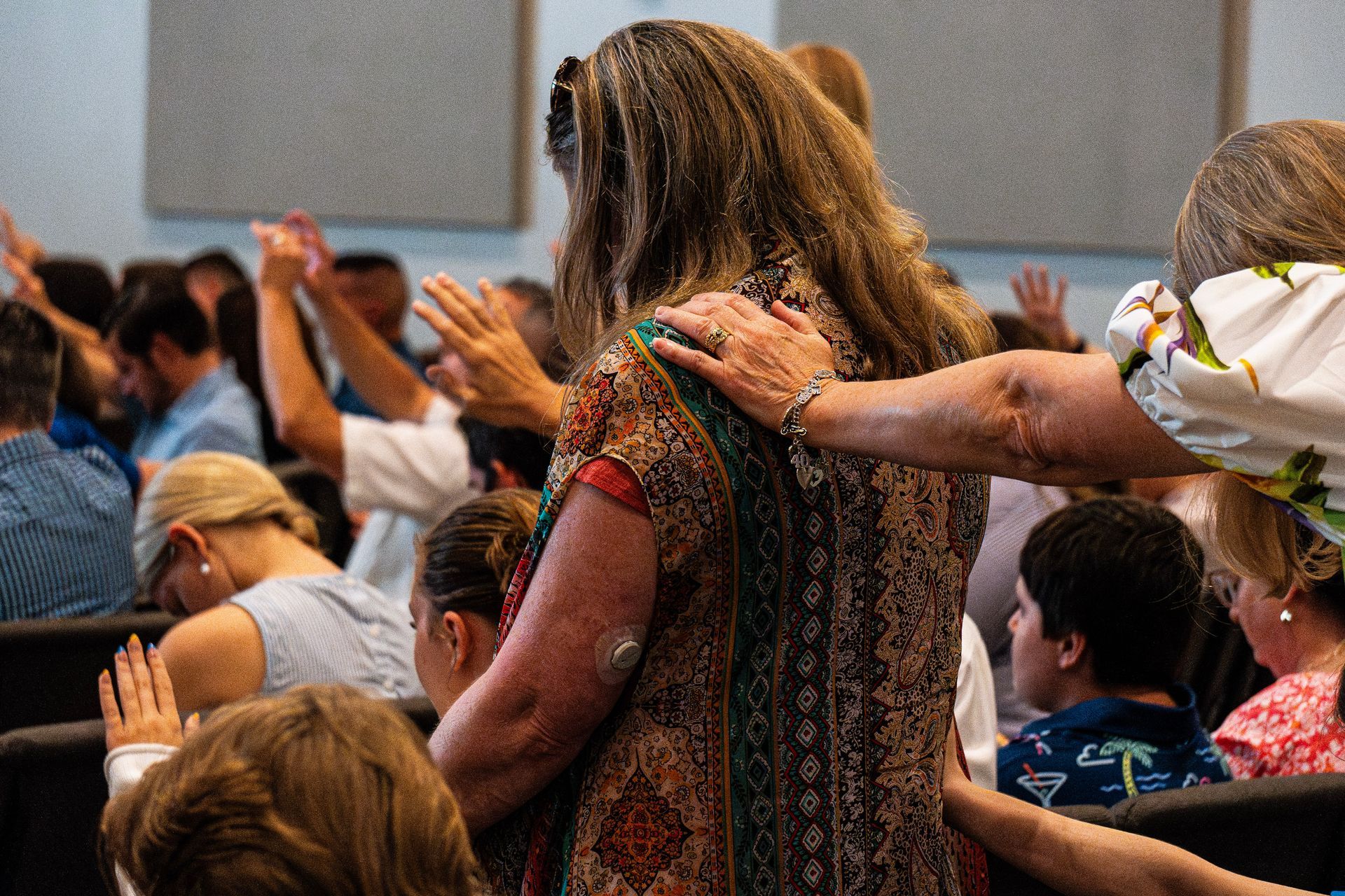 A group of people are standing in a circle with their hands on each other.