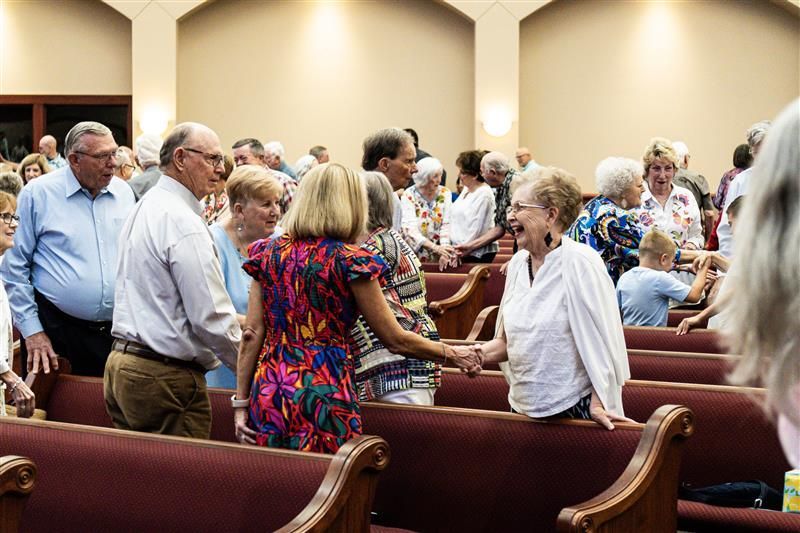 A group of people are shaking hands in a church.