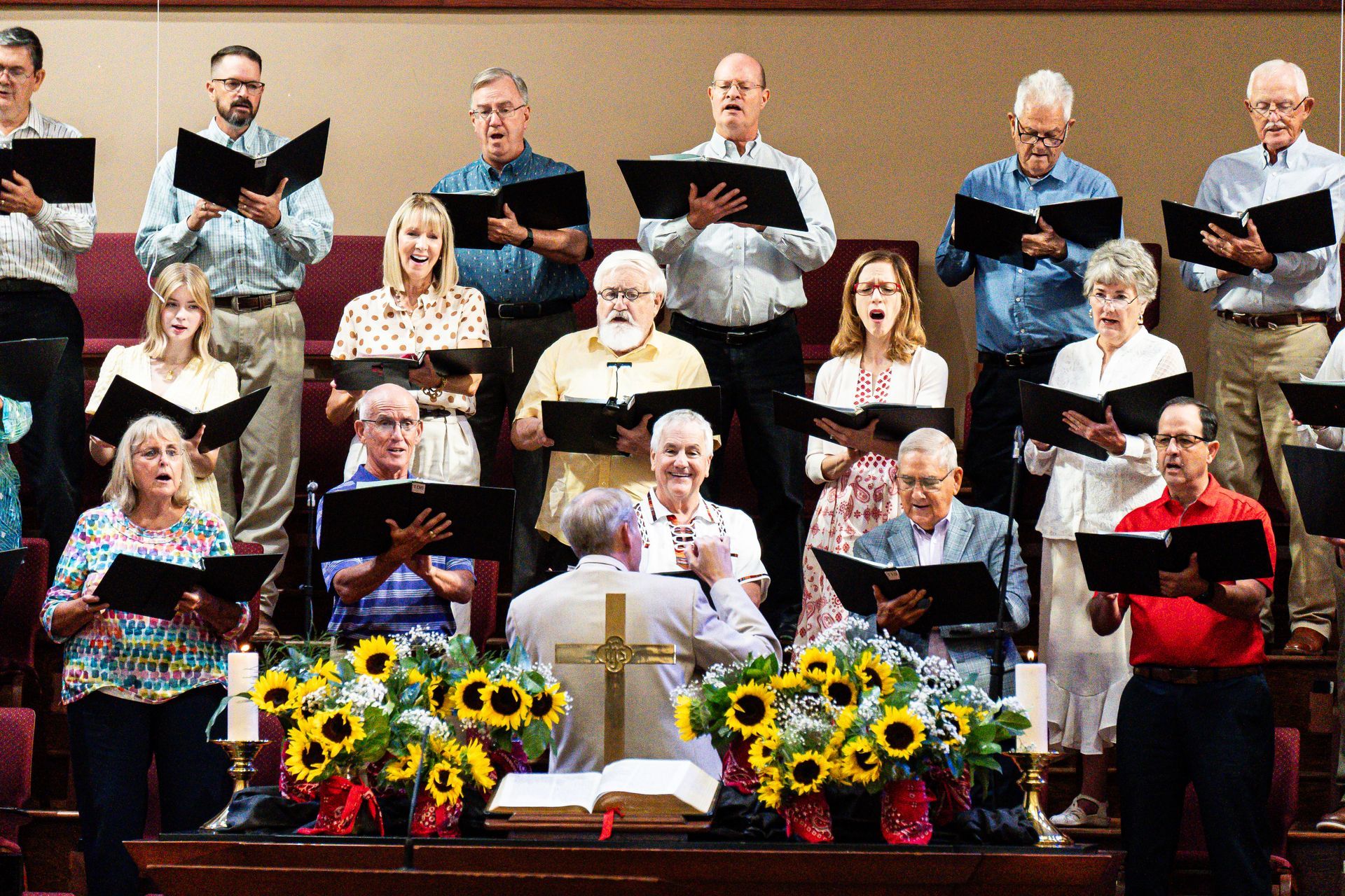A large group of people are singing in a church choir