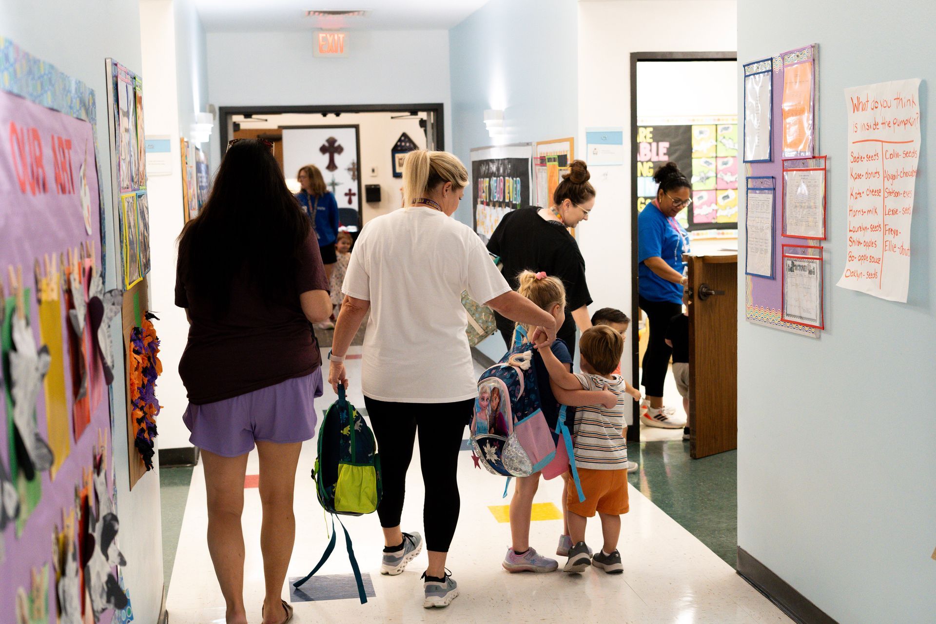 A group of people are walking down a hallway in a school.