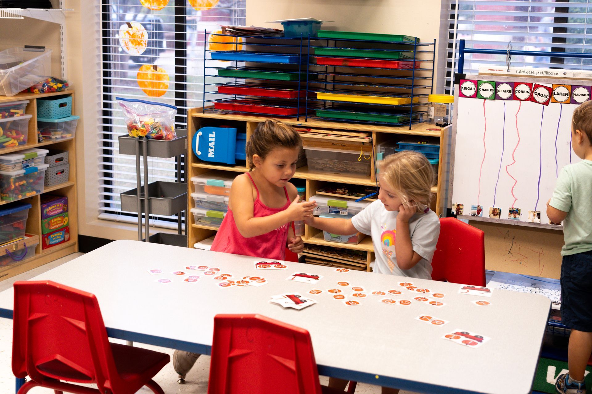 A group of children are sitting at a table in a classroom.