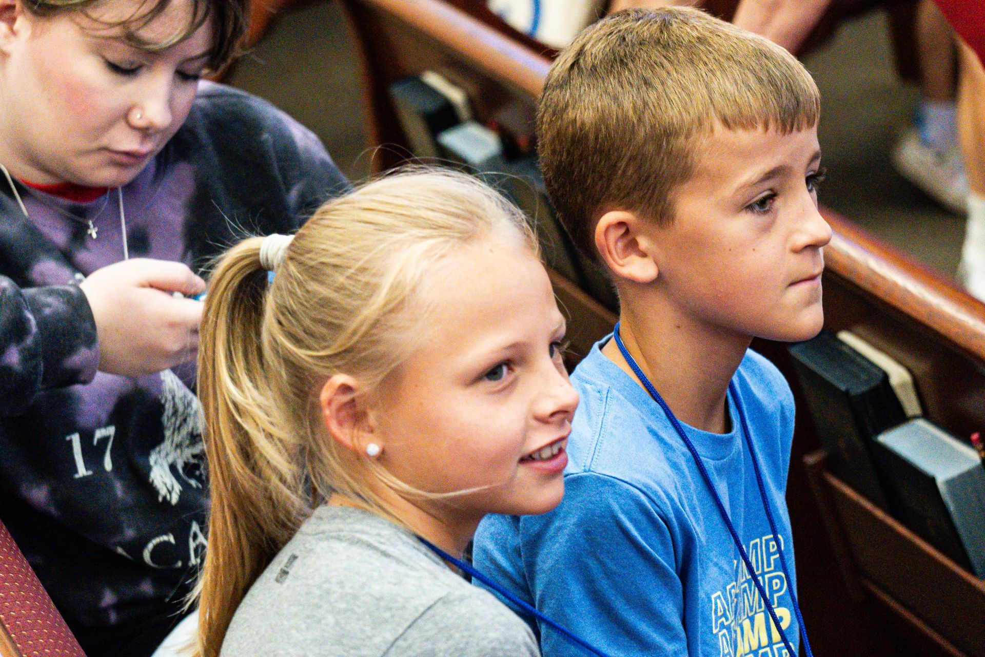 A boy and a girl are sitting next to each other in a church.