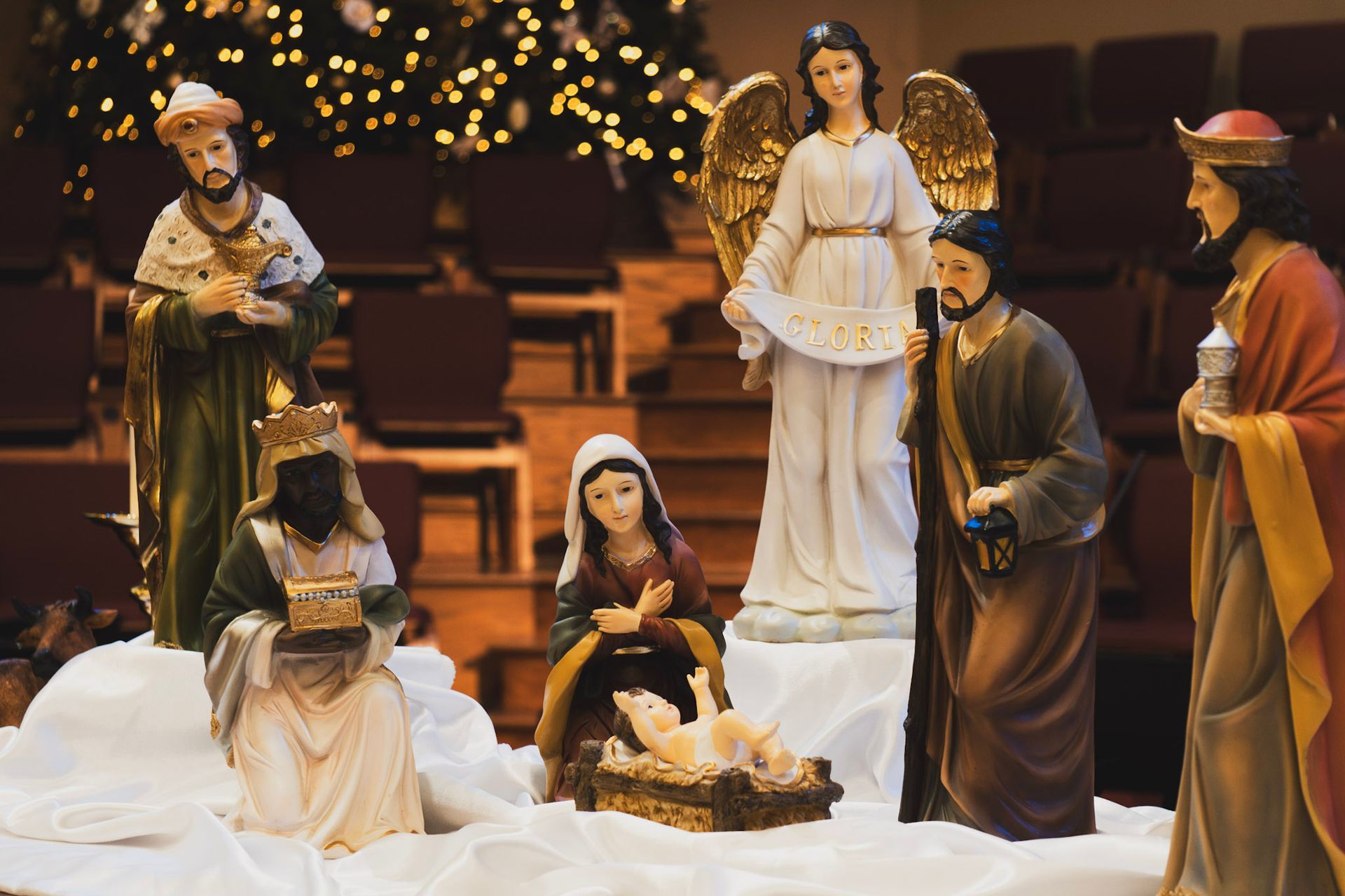 Nativity scene with figures around a manger; includes Mary, Joseph, angel, wise men, and baby Jesus.