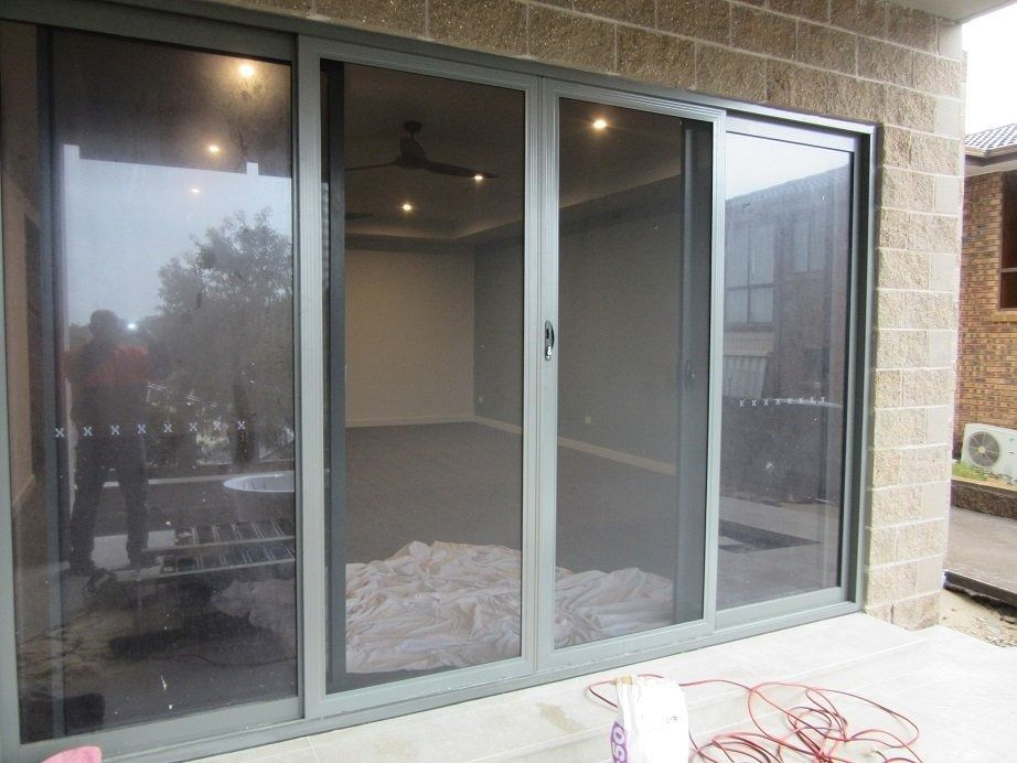 Sliding glass patio doors on a brick wall, showing an empty room inside.