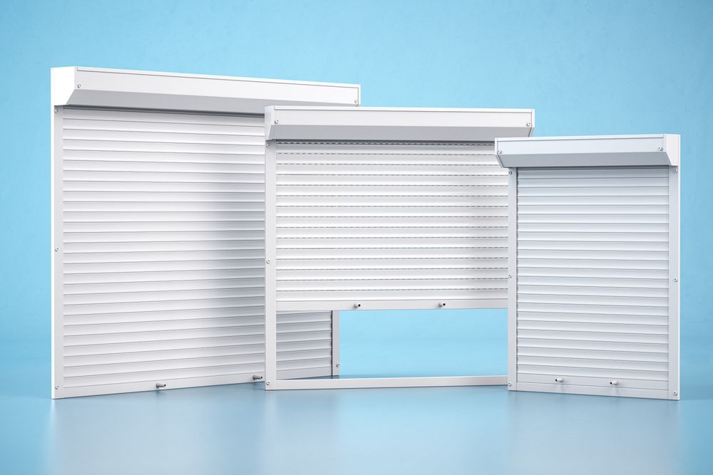 White roll-up garage doors on a light blue background, showing three sizes and styles