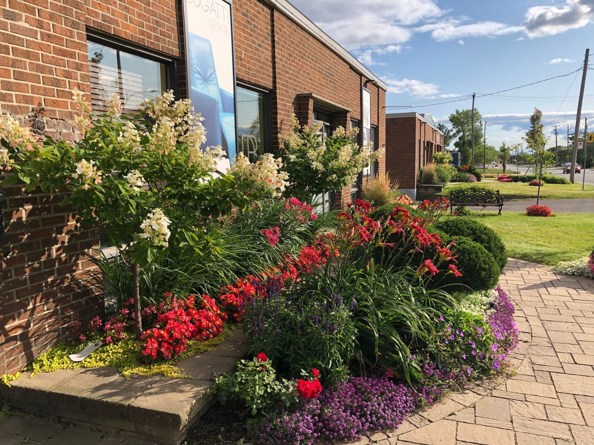 Un bâtiment en briques avec un jardin devant.