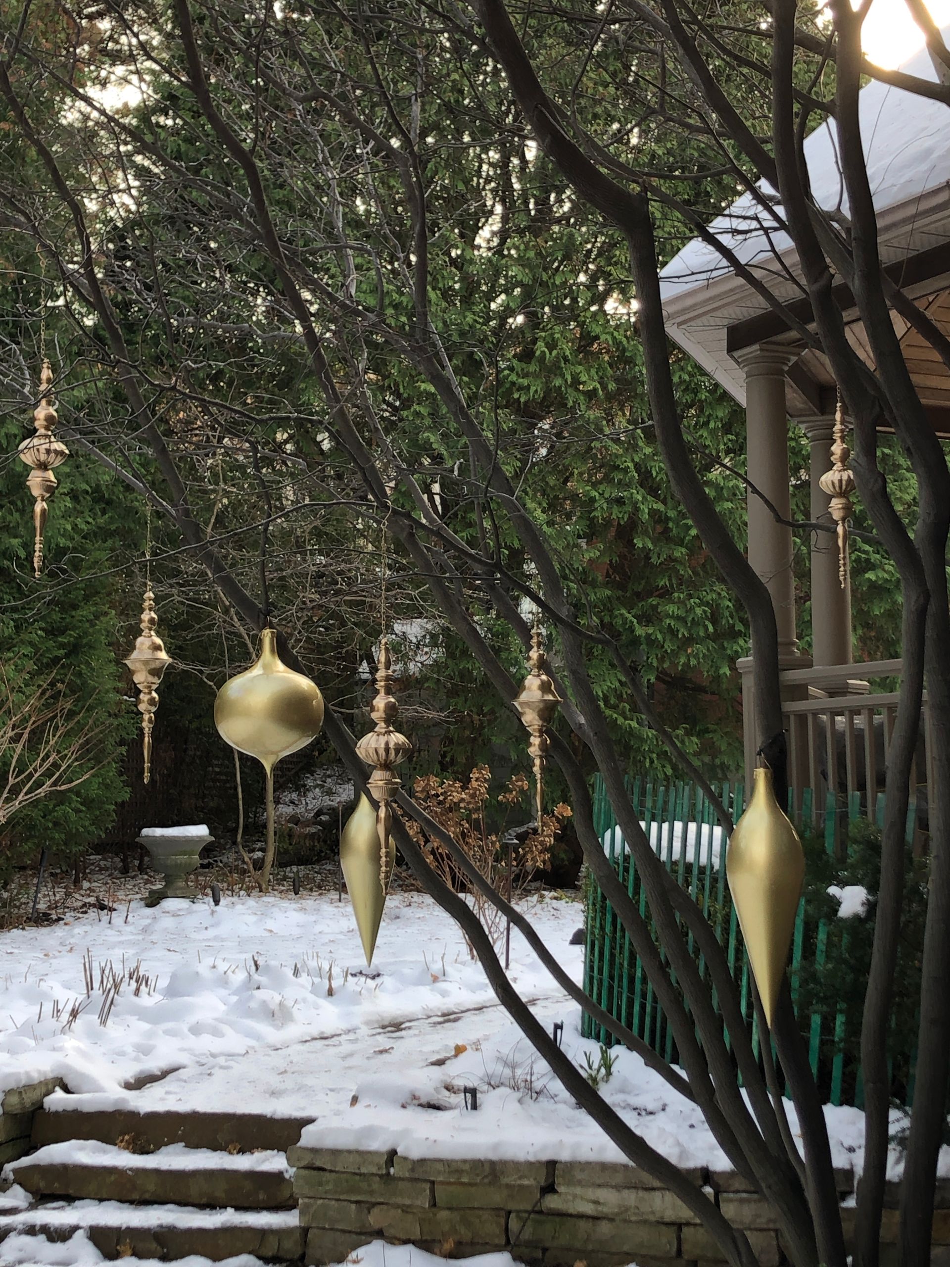 Décorations de Noël suspendues à un arbre dans une cour enneigée