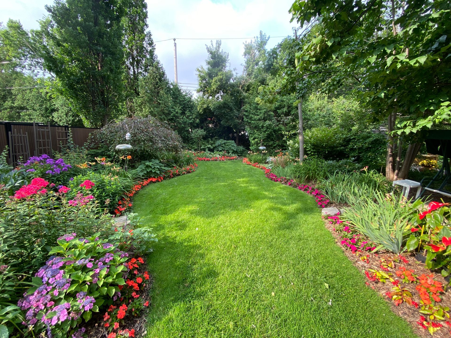 Un jardin verdoyant et luxuriant rempli de fleurs et d'arbres.