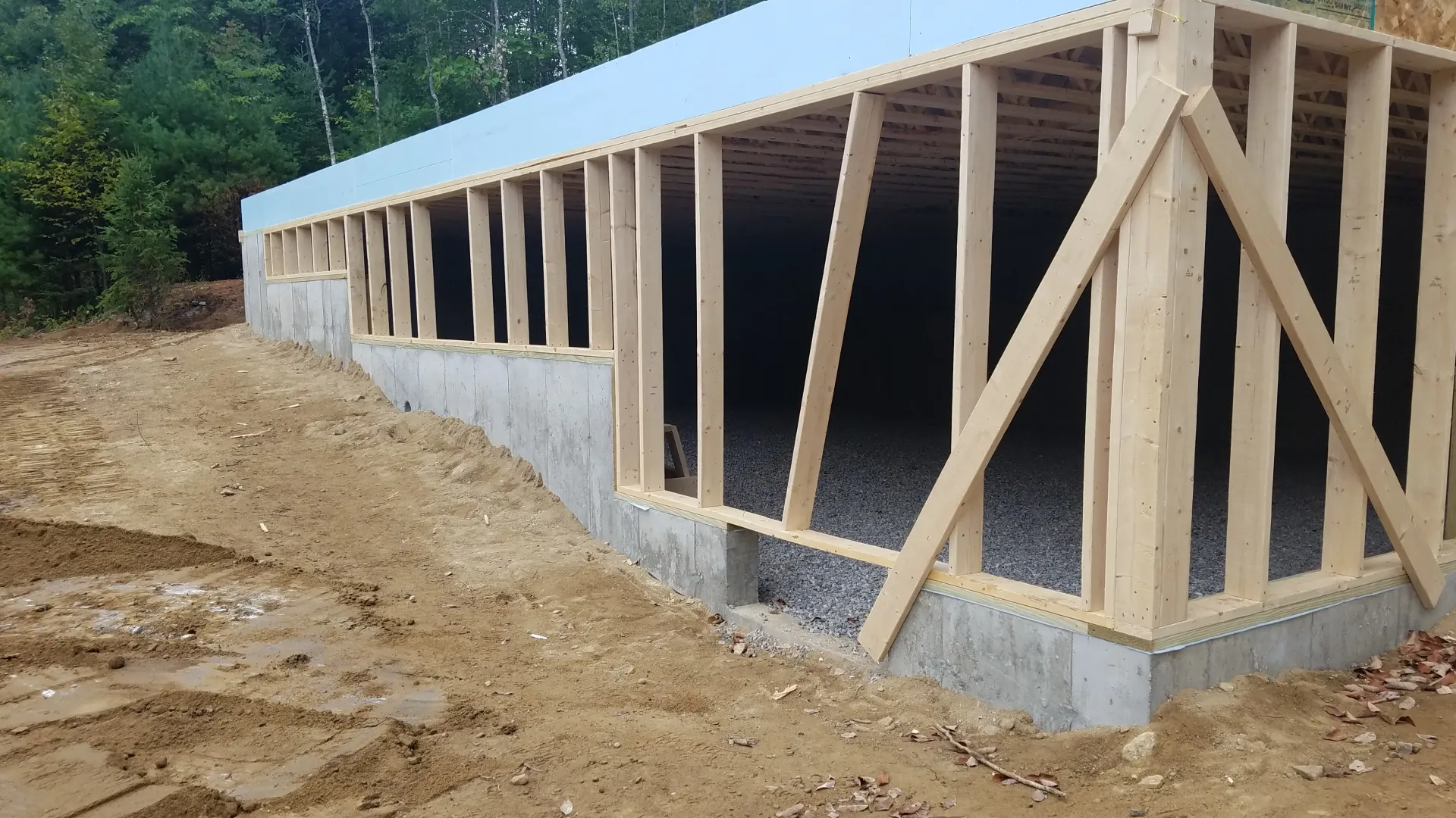 A large wooden structure is being built on top of a dirt field.