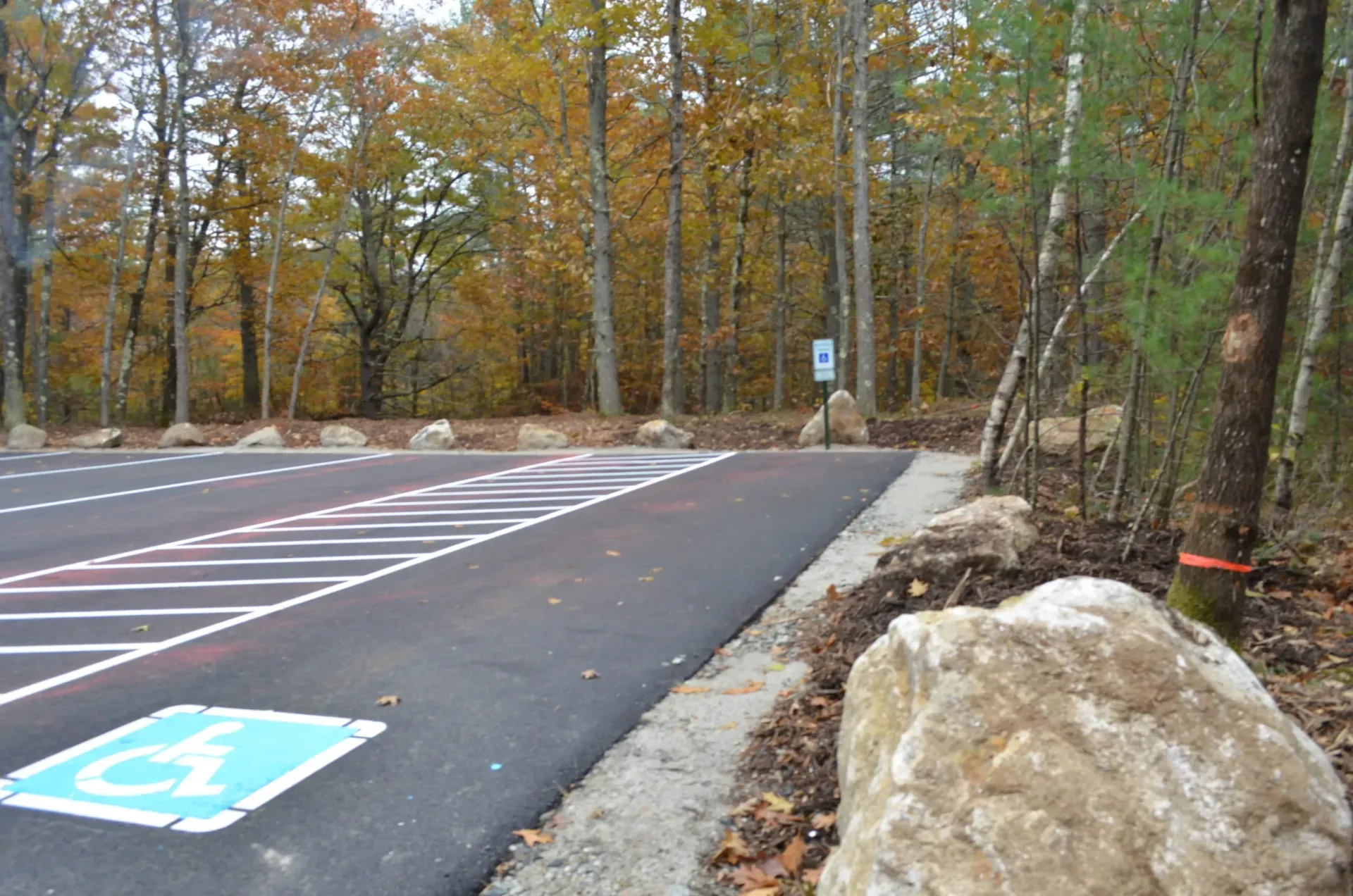 A parking lot with a handicap sign in the middle of it