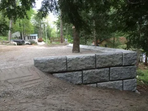 A stone wall is being built in the middle of a dirt road.