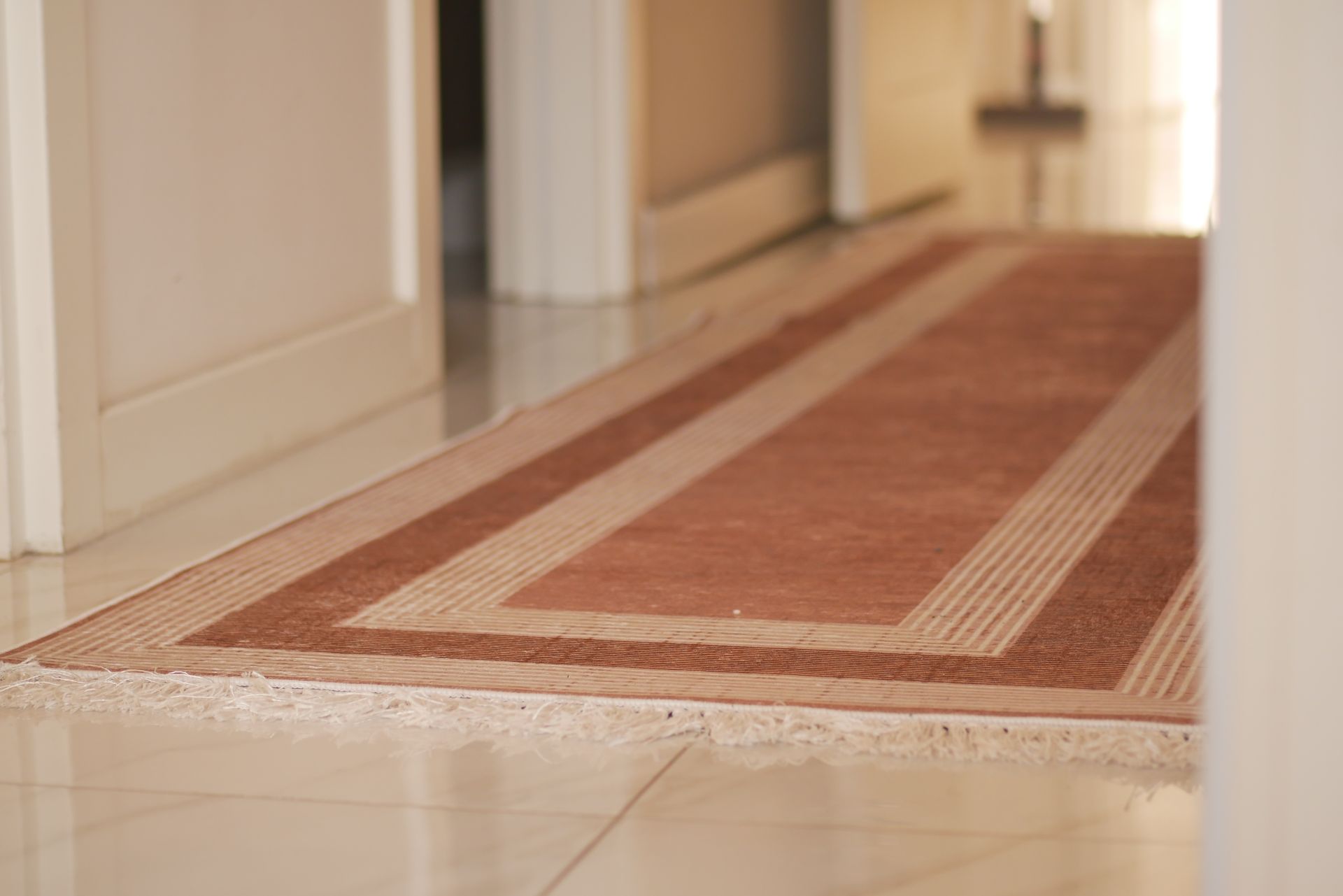 Brown hallway runner rug in a white hallway.
