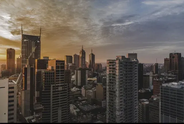 Sunset city skyline with high-rise buildings and warm orange clouds