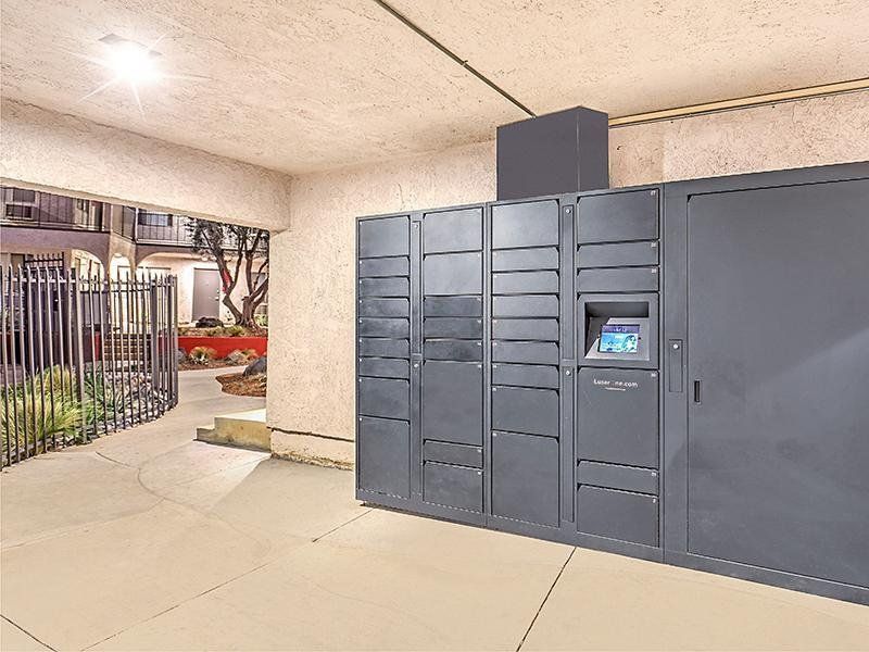 A room with a lot of lockers and a fence in the background.
